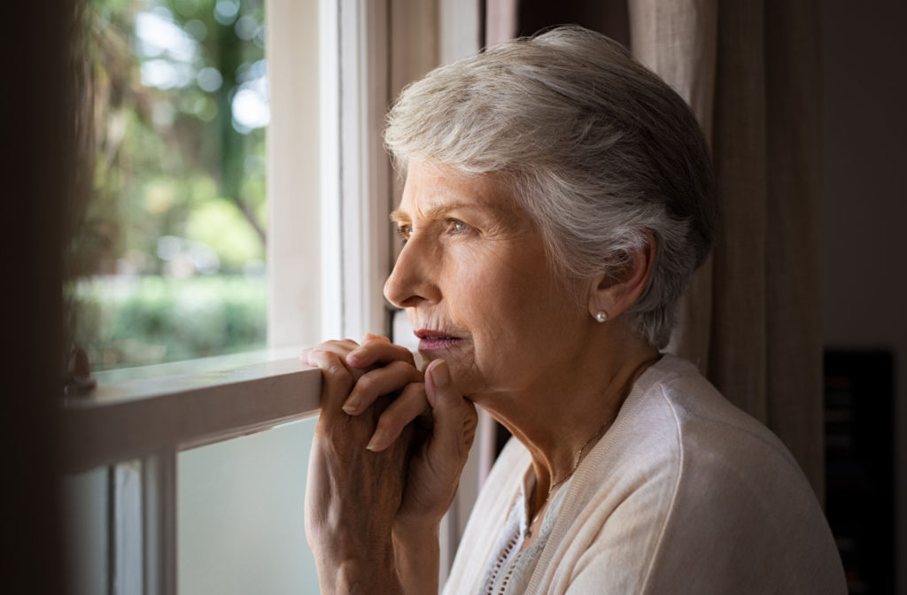 Senior woman gazing out a window.