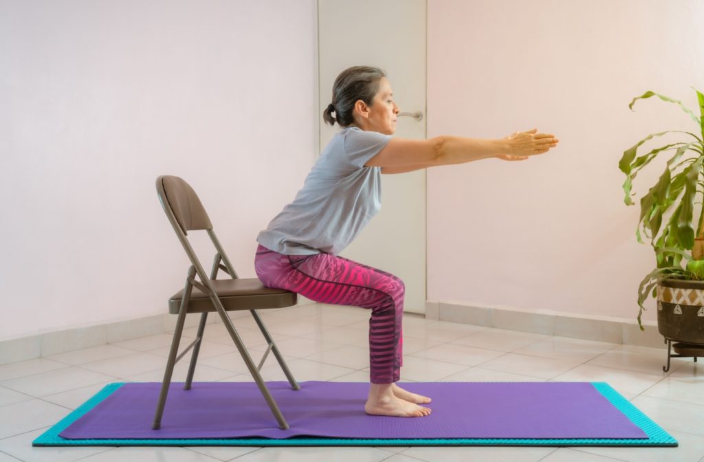 A senior doing a chair yoga stretch as part of their limited-mobility physical activity routine.