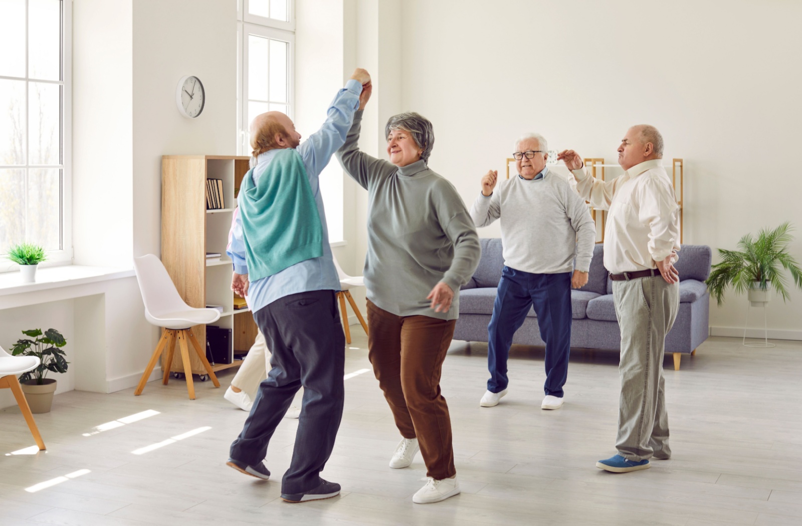 Four seniors dancing to music together.