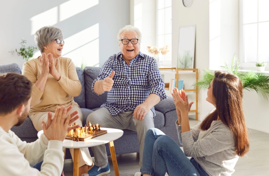Happy seniors enjoying a visit with their family in an assisted living community.