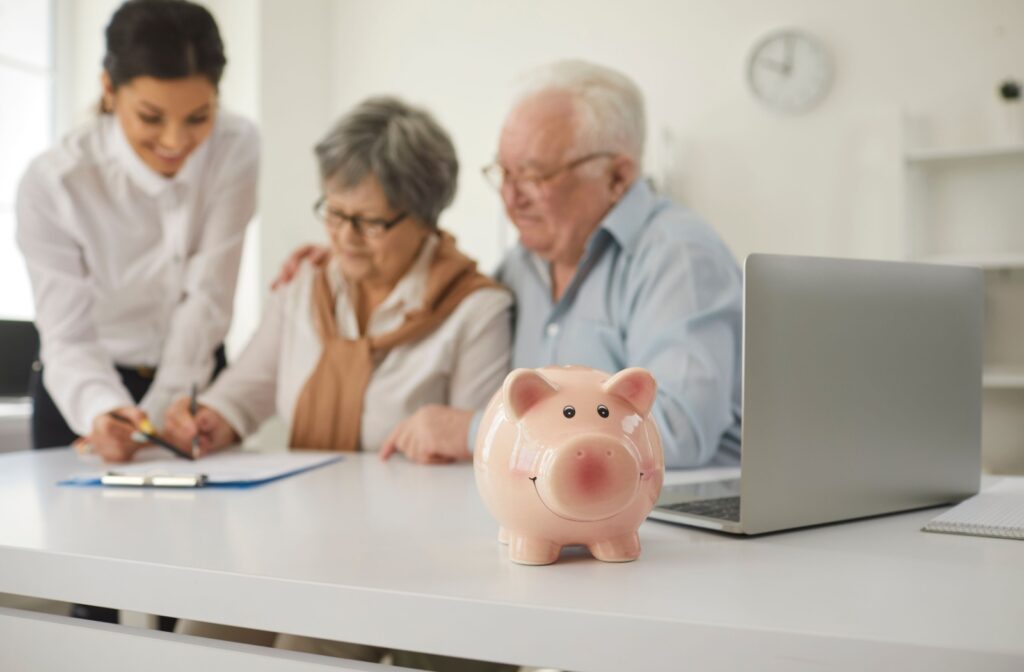 Seniors organize their finances with a small piggy bank displayed in the foreground.