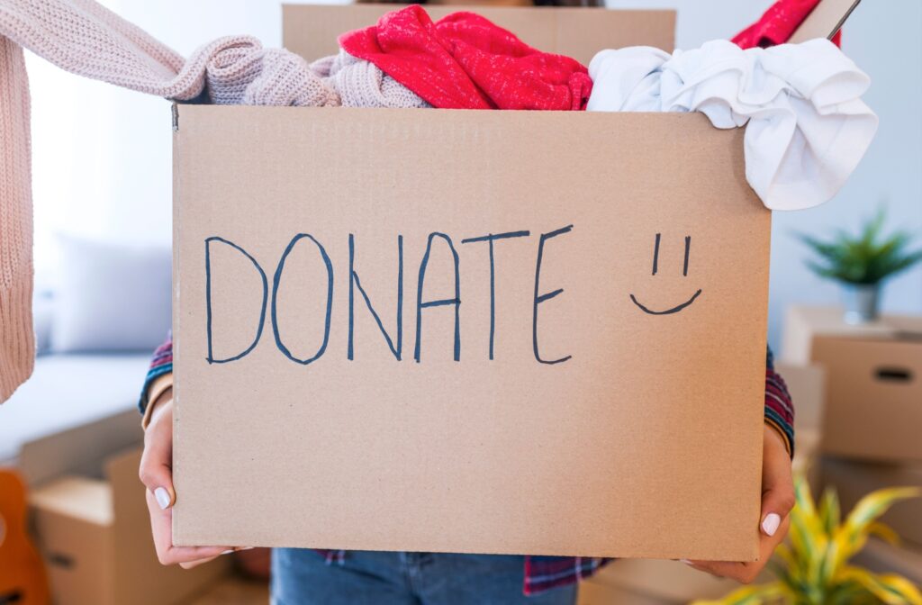 Someone brings things to the donation bin after helping to downsize.