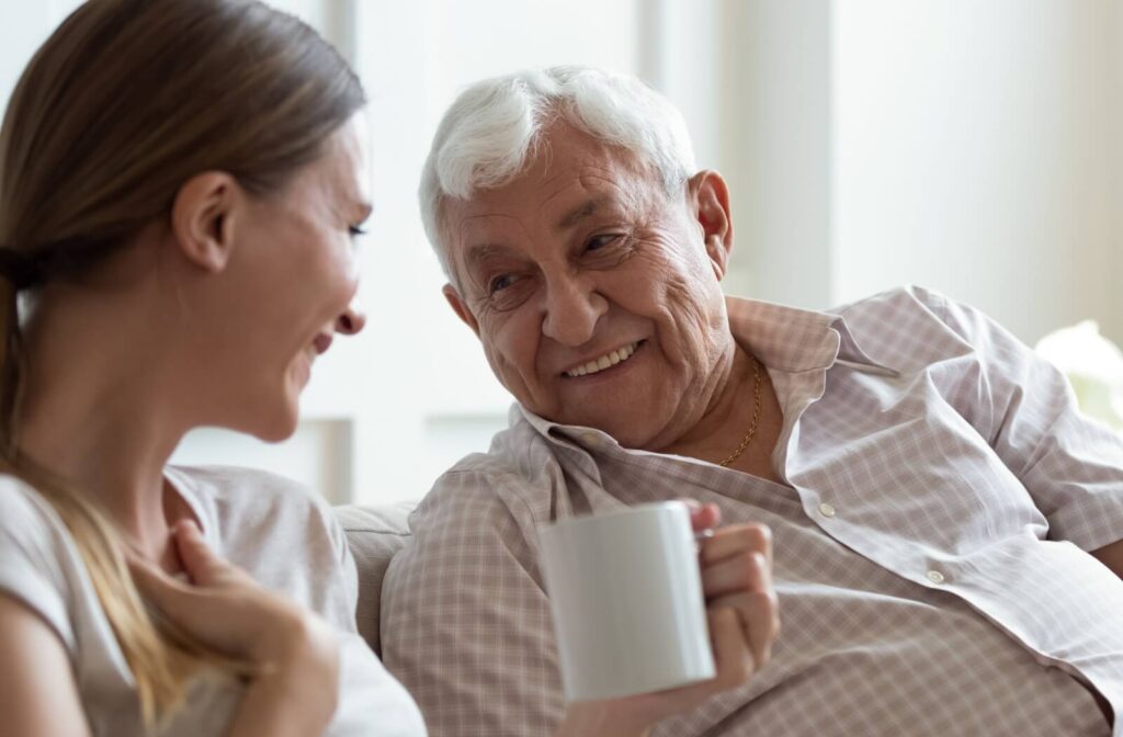 A senior laughs during a conversation together with their family member.